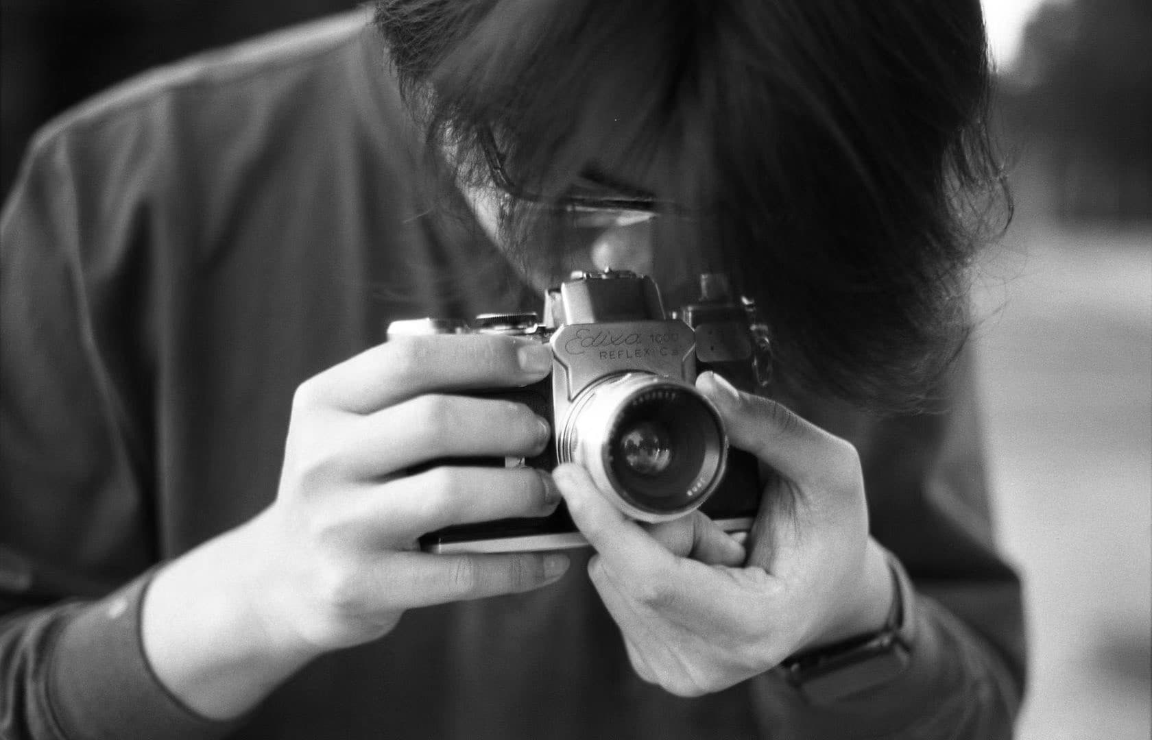 A friend at home holding a Sony camera, taking a photo